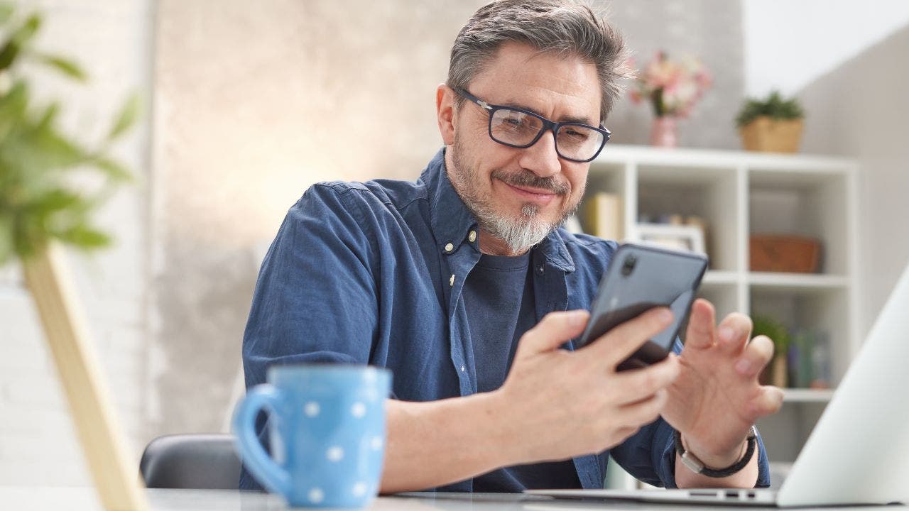 1-MAN-SMILES-AT-PHONE.jpg