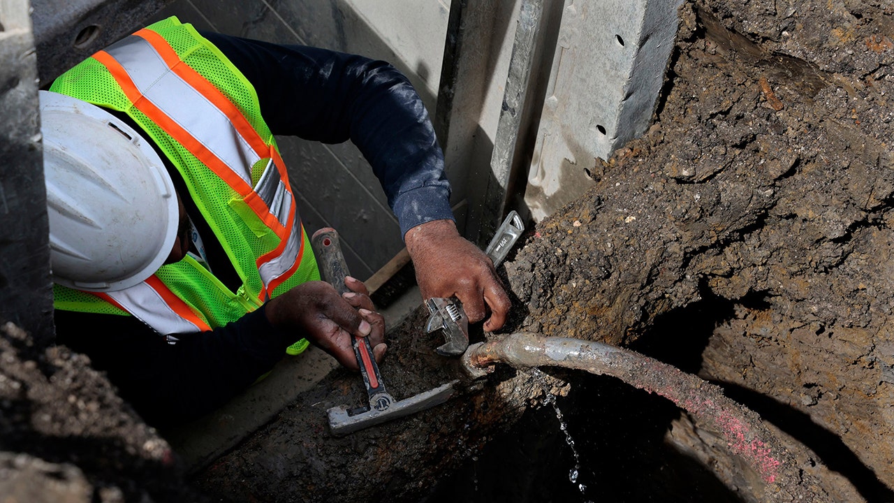 worker-repairs-leaky-lead-pipe.jpg