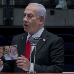 netanyahu-holds-up-bibas-family-photo.png